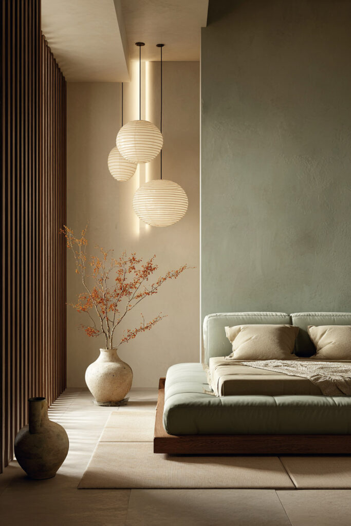 Sage green bedroom with platform bed, neutral bedding, paper lantern pendant lights, and warm wood accents for a minimalist look.
