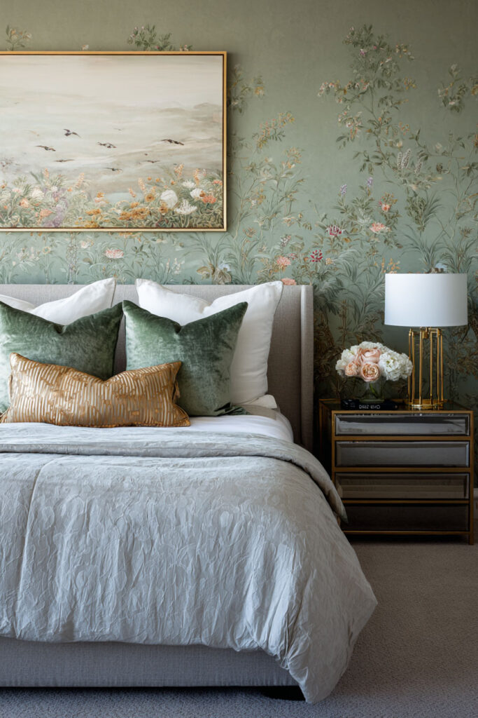 Sage green bedroom with floral wallpaper, velvet pillows, and modern nightstand creating a cozy yet elegant statement wall.