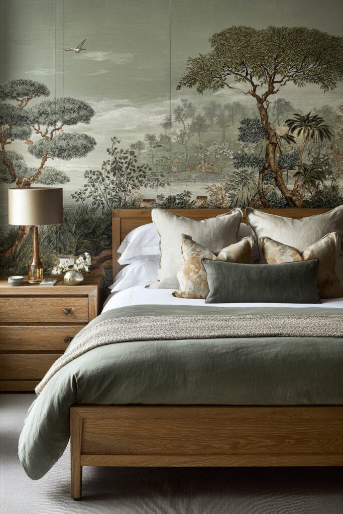 Sage green bedroom with nature mural, oak bed frame, and neutral linen bedding for a calm, organic look.