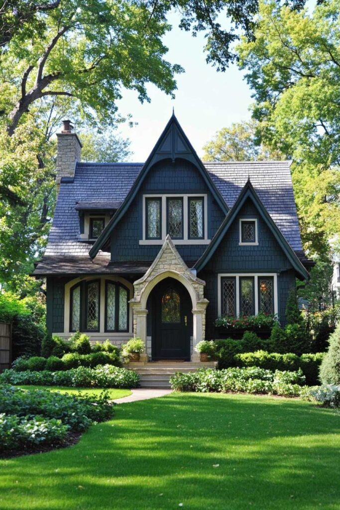Dark green Tudor-style home with steep gables, stone arch doorway, and lush front garden.