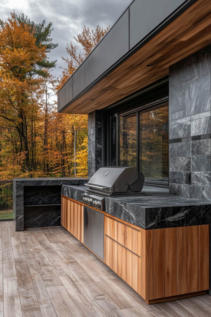 Modern outdoor grill station with dark stone countertops, wood cabinets, built-in grill, and covered patio design