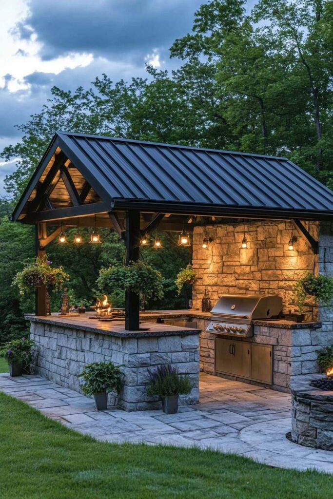 Covered outdoor grill station with stone walls, metal roof, built-in grill, and warm outdoor lighting