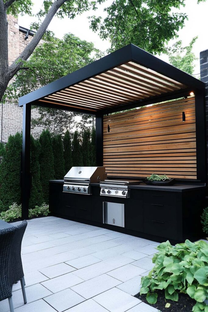 Modern outdoor grill station with black pergola frame, wood slat wall, and built-in grill