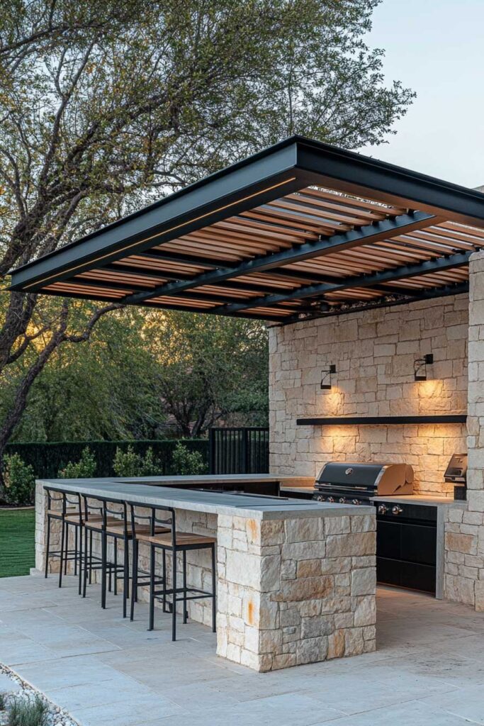 Outdoor grill station with stone island, bar seating, built-in grill, and modern pergola in a landscaped backyard.