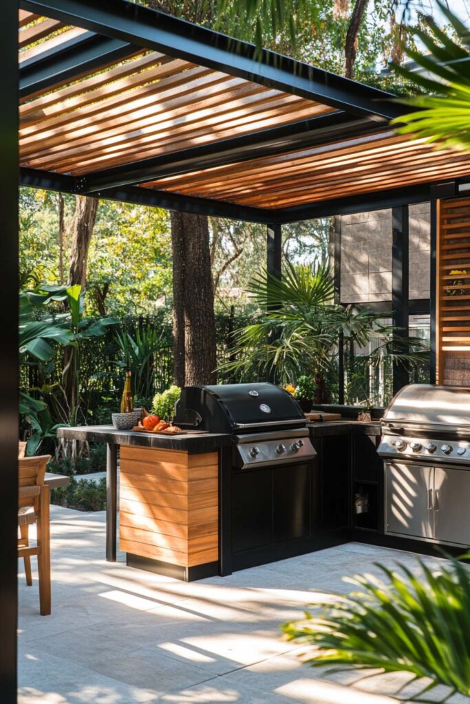 Modern outdoor grill station with black cabinets, wood accents, dual built-in grills, and a slatted pergola surrounded by tropical greenery.