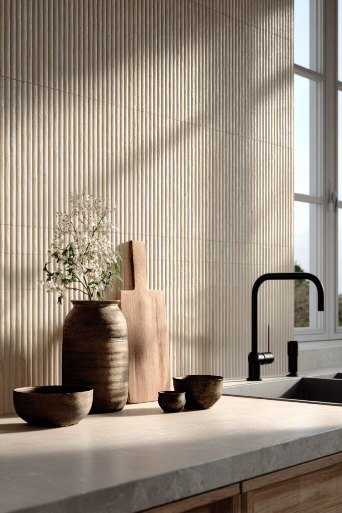 Neutral kitchen with ribbed tile backsplash and dimensional textured surfaces, featuring warm wood accents and modern minimalist kitchen design.